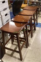 Set of four saddle style wooden bar stools with