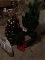 Two small Christmas trees, lighted wreath and