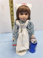 Porcelain doll with red cross hat and cross