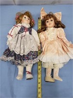2 porcelain dolls ( each missing a shoe )