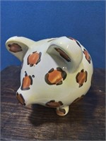 Cream-colored piggy bank with a coin inside