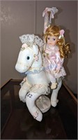 Blonde Haired China doll on white carousel horse
