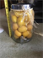 Large glass dispenser with artificial lemons.