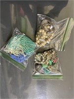 costume jewelry bag of bracelets, pins, beads and