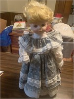 Porcelain doll in dress with petafore