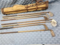 7 Antique wooden shaft golf clubs with bag