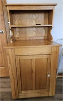Wooden kitchen cabinet w/ wine racks in bottom.
