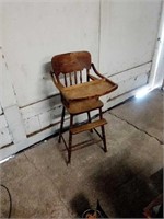 Vintage wooden high chair, tray lifts over chair.