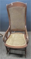 Wood rocking chair with cane back and seat.