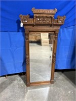 Ornate mirror with wood header and frame,