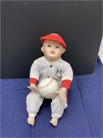 Baby boy holding a baseball porcelain doll
