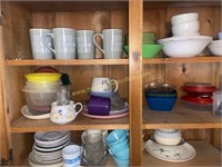 Dishes, mugs, in cabinet above fridge