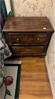 Wooden night stand with gold colored hardware.