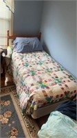 Wooden twin bed with bedding