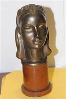 A Metal Bust on a Wood Stand