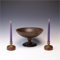 A pair of antique wood and brass candlesticks and