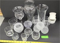 Assorted glass candle holders and vases.