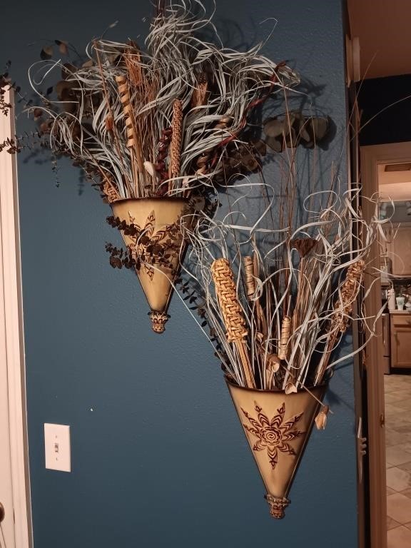 Pair of metal wall vases with dried plants.