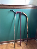 Two wooden canes, one plastic cane