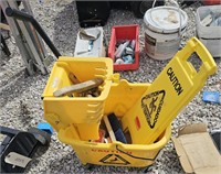 Yellow mop bucket, caution sign, brushes