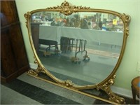 Large gilt shield shaped over mantle mirror