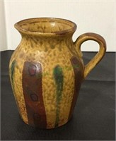 Small pottery pitcher measuring 5 inches tall.