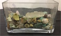 Assorted mineral rocks in a glass vase. Varying