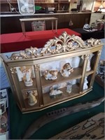 Gold curio shelf with chotchkeys