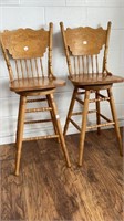 2 oak swivel chairs with pressed back designs,