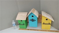 3 WOODEN BIRD HOUSES ATTCHED TO A BOARD