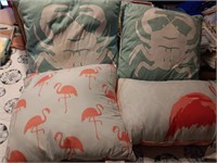 4 decorator pillows, 2 crabs and 2 flamingos.