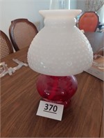 Red base kerosine lamp with milk glass