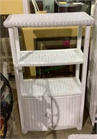 Three tiered white wicker shelving unit with