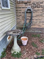 Birdbath, polkadotted pot and garden hose unknown