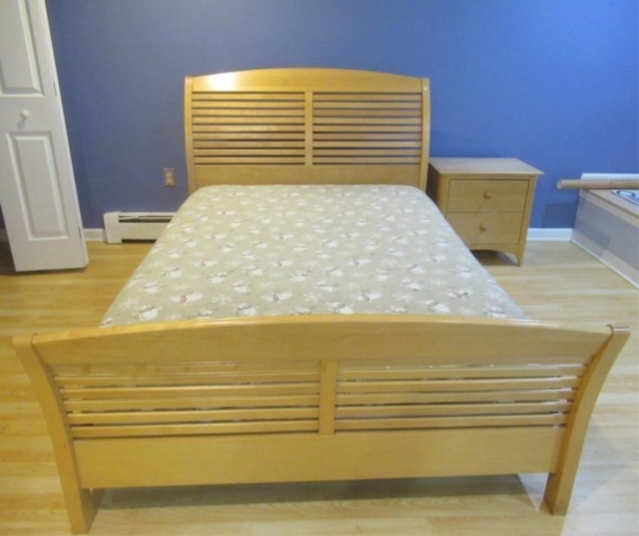 Full size bed with mattress and nightstand.