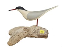 Carved wooden shorebird on driftwood, bird