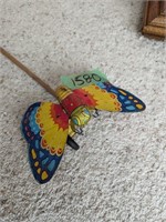 Vintage tin butterfly on wheels with push stick