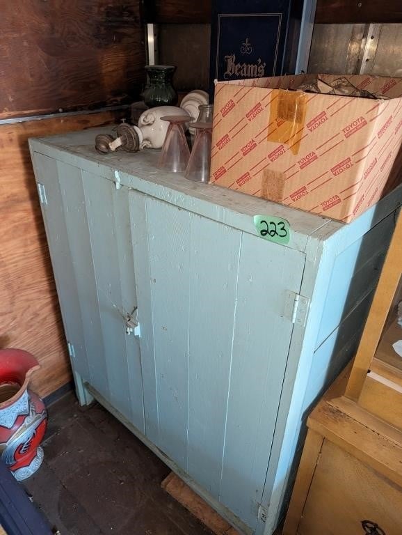 Antique green wood cabinet, full of colored glass