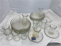Pile of glass party/sandwich trays with glasses.