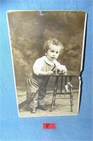 Early photo post card featuring a young boy with t