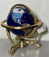 Globe on brass frame with land masses shown by