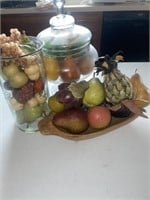 Fake fruit, glass jars and wooden bowl