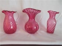 Three Cranberry Glass Pitchers