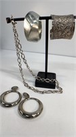 2 chunky cuff bracelets, a silver tone neck chain