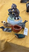 Small duck figurines and a raccoon statue