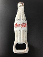 Cast iron bottle opener in the shape of a Coca-Col