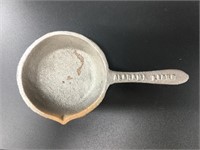 Cast iron ladle with legs about 7in long.