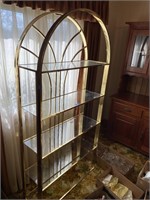 Shelf unit brass in color with glass shelves