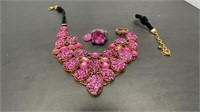Pink and gold toned necklace with rings and