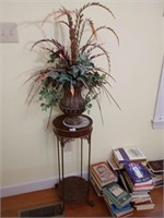 Metal plant stand with faux floral arrangement.